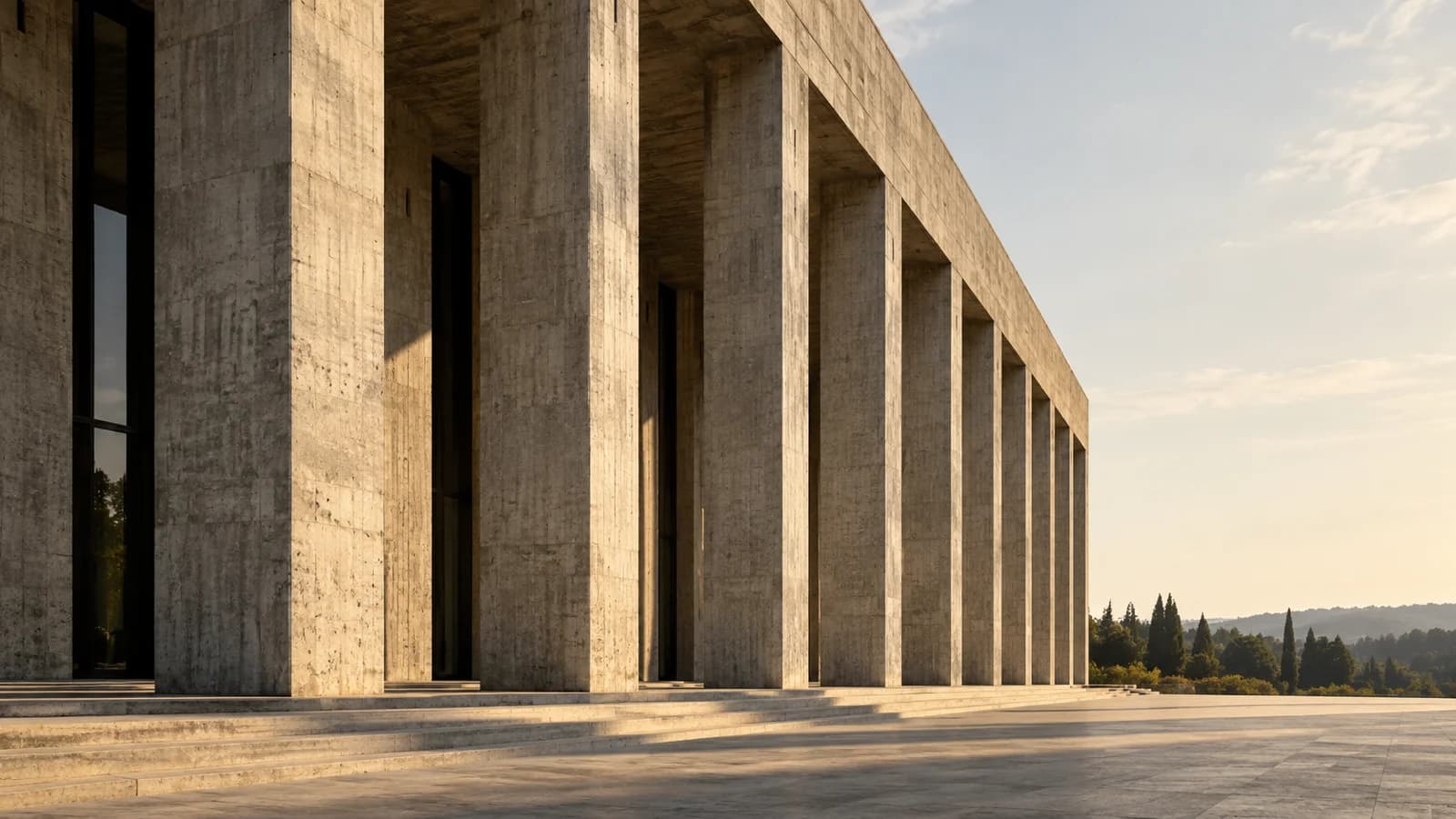 A monumental concrete civic colonnade casts long shadows beneath a pale afternoon sky.